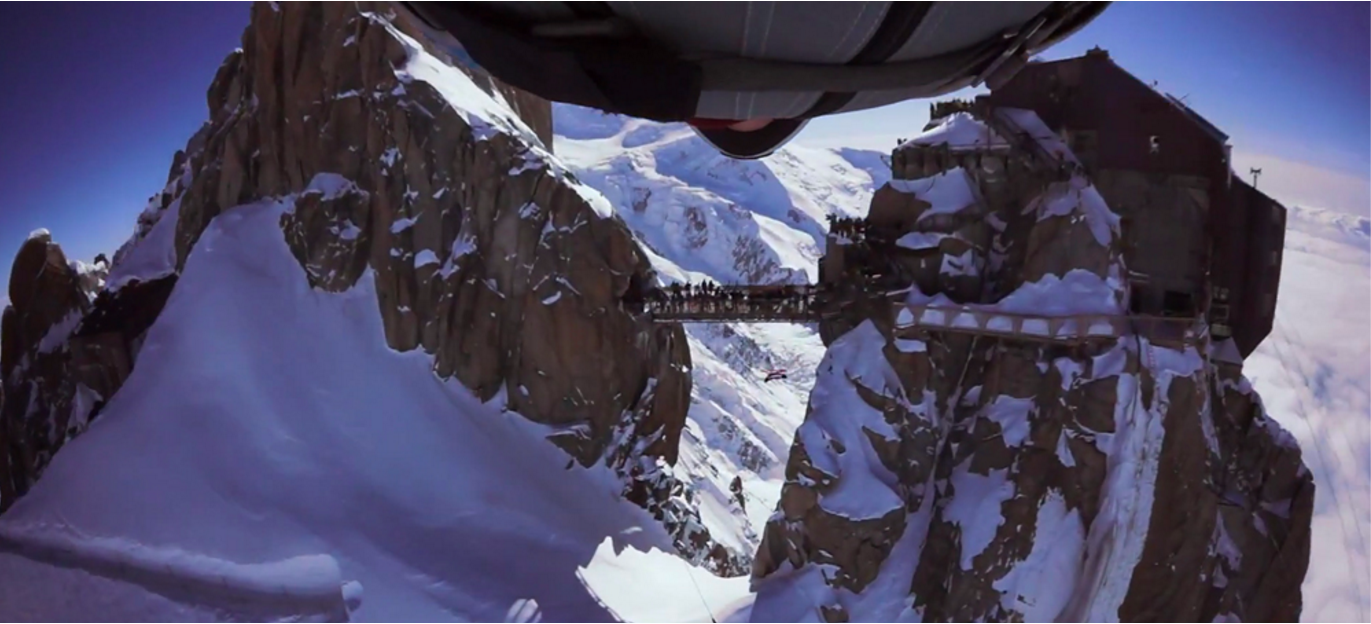 Wingsuit flyer approaches the Aiguille du Midi Bridge in Chamonix, France Wingsuit flyer approaches the Aiguille du Midi Bridge