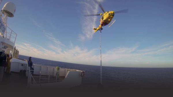 Rescue helicopter pulls up stranded members of ship