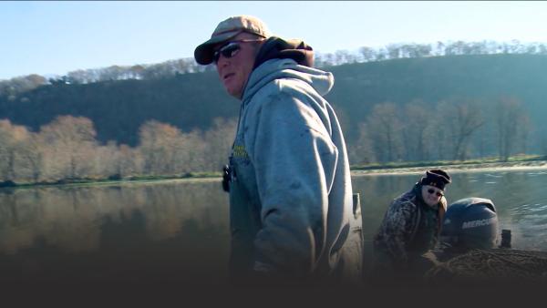 Two crew members drive a boat.