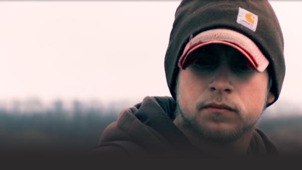 A crew member looks into the camera.