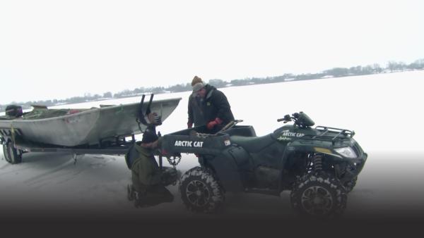 A boat being towed on an icy lake.