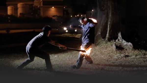 A stuntman is lit on fire filming an action scene