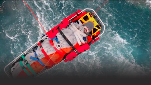 Man is hoisted in a Coast Guard helicopter litter