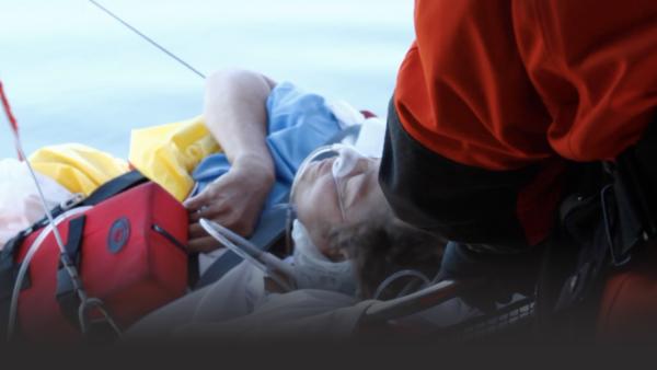 Man being pulled into a helicopter on a stretcher