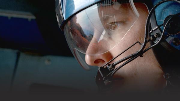 Men talking into mouthpiece in a helicopter