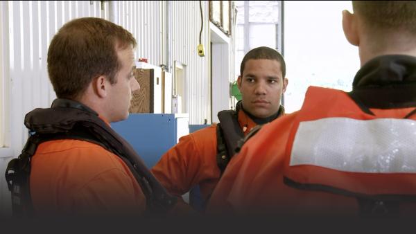 Men in Coast Guard listening to their commander