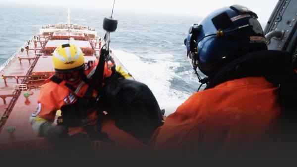 Man repels from a helicopter to a barge