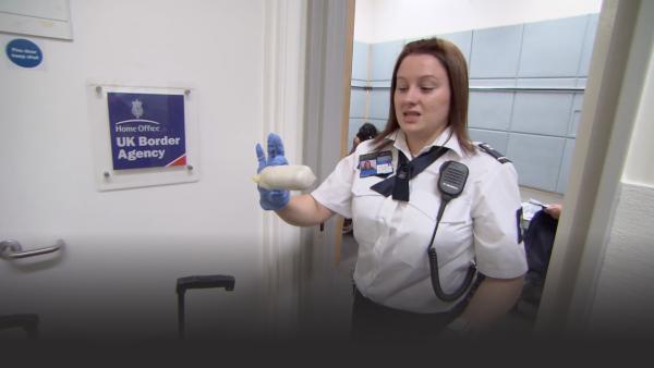 Customs officer holding a package of cocaine. 