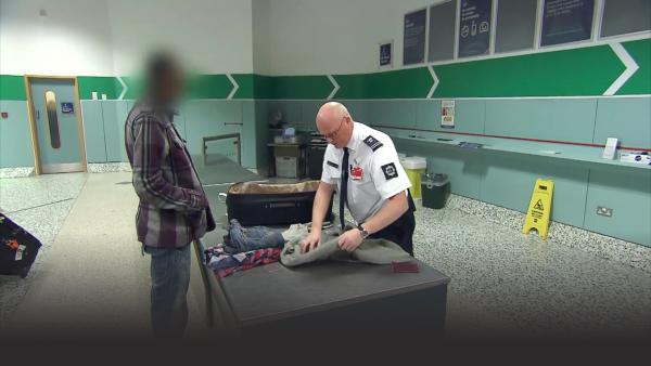 Custom officers checking a mans bag