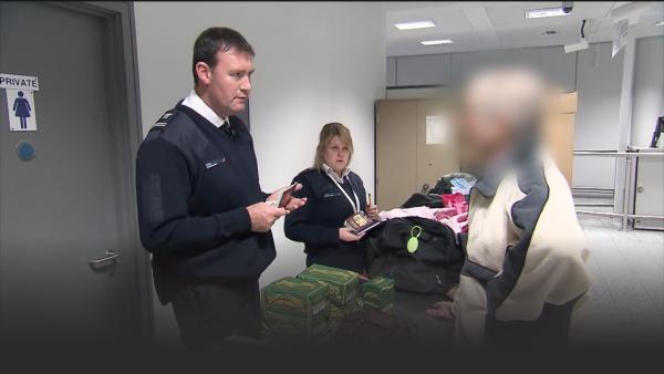 Custom officers talking to a suspicious man. 