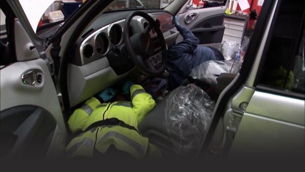 Customs searching a suspicious man's vehicle.