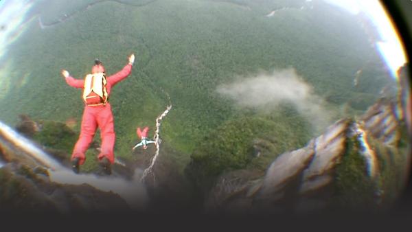 Women base jump off of cliff