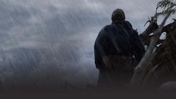 Man standing in middle of rain