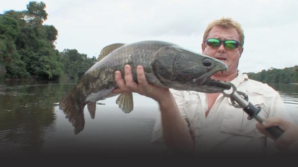 Man holds up a prehistoric looking fish with huge black eyes