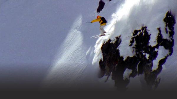 Skier gets set for a jump on a steep slope