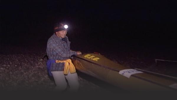 Man with a kayak in the dark
