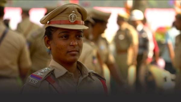 A policewoman stands in a crowd of cops