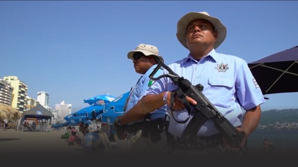 Armed police patrol a beach