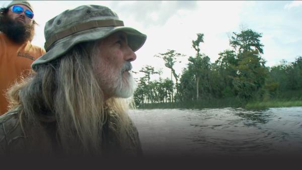 Man on a. boat approaches an island