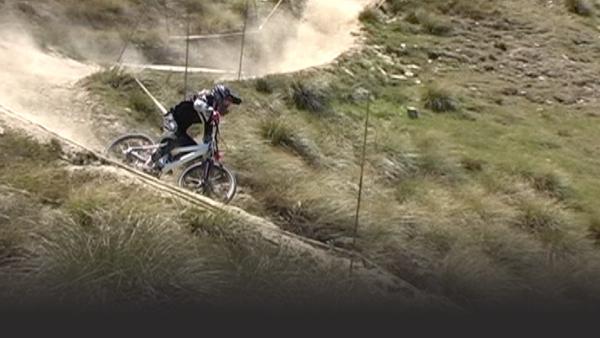 Female mountain biker makes a sharp right turn down a mountain trail