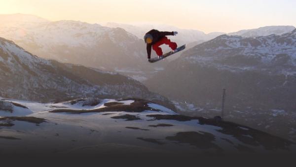 snowboarder grabbing tail of board suspended mid-air