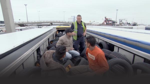 Seven Indians hiding behind tires. 